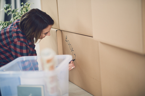 woman packing up books into several boxes