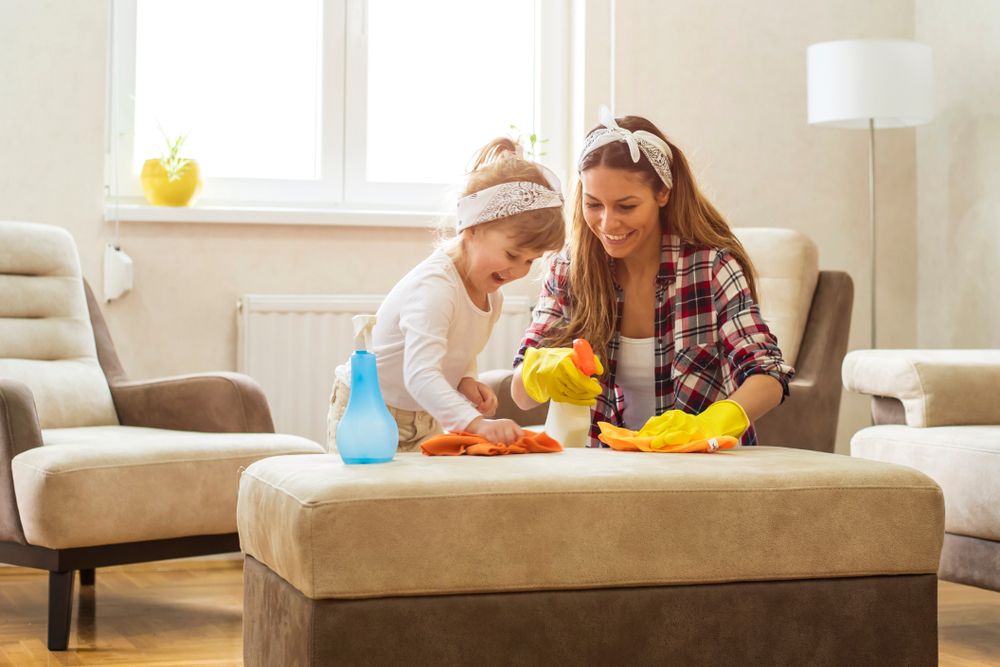 A mother and daughter smile as they clean together