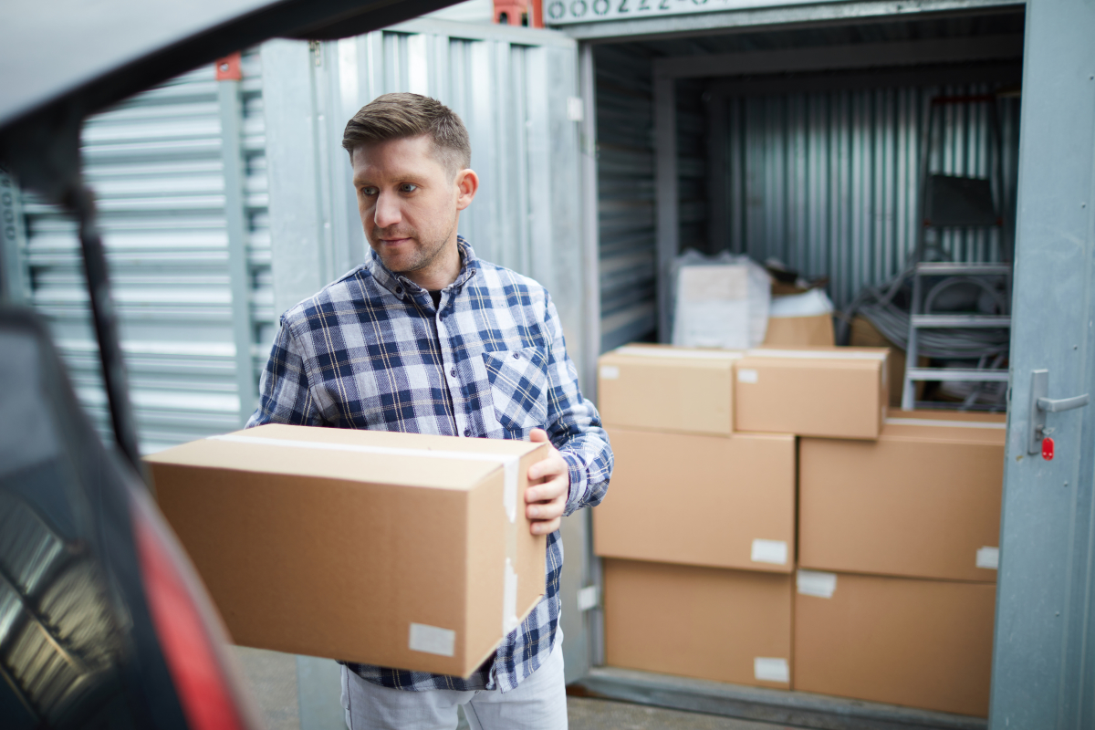 man moving boxes into his storage unit
