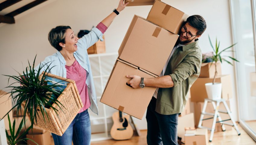 man and woman moving boxes from their home
