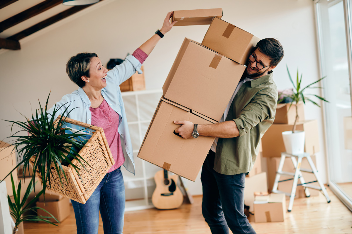 man and woman moving boxes from their home